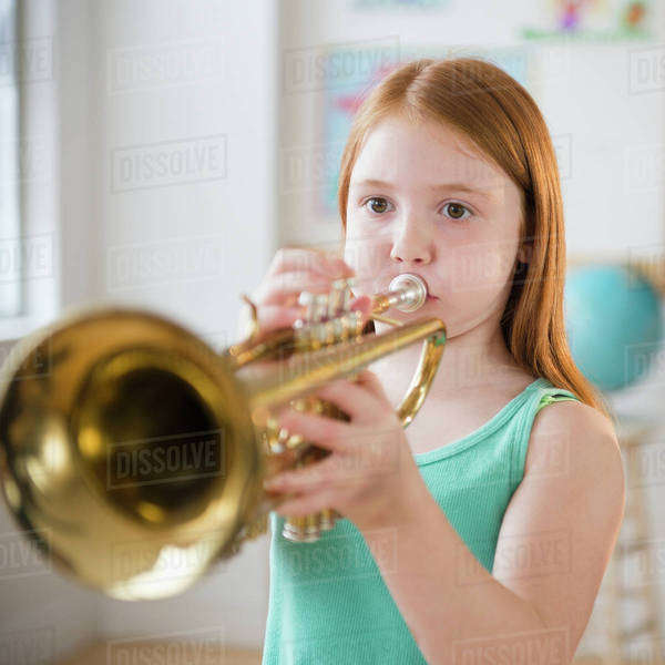 Portrait of school girl (89) playing trumpet during music class