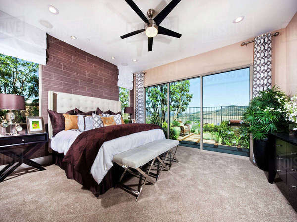 Interior of bedroom with bed end ottoman - Stock Photo - Dissolve