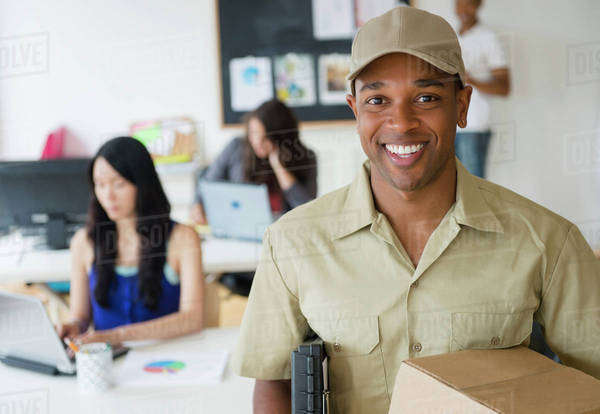 Delivery man smiling in office - Royalty-free Stock Photo | Dissolve