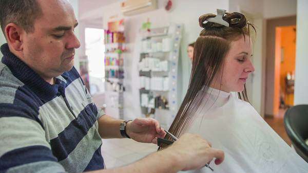 Man Trimming Young Woman Hair At Salon Side Slow Motion Shot Of