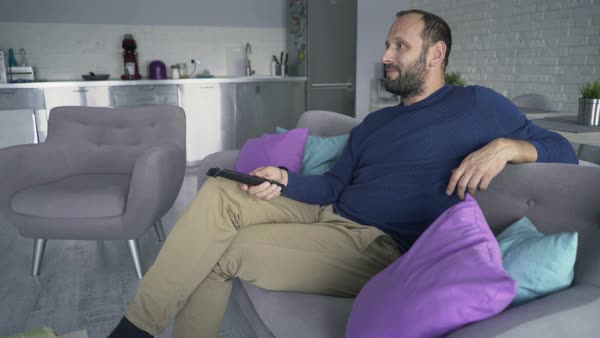 Man Watching Tv Sitting On Sofa At Home Stock Video Footage