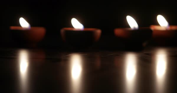 Selective Focus Adjustment Blur Bokeh Of Traditional Clay Diya Lamps Lit During Diwali Celebration Stock Video Footage Dissolve