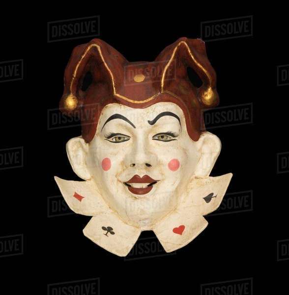 Smiling venetian jester face mask with jester hat on black background