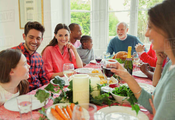 Multi-ethnic multi-generation family enjoying Christmas dinner at table