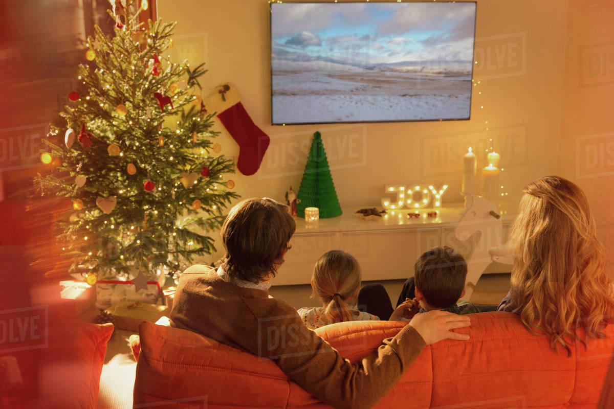Family watching TV in Christmas living room Stock Photo Dissolve