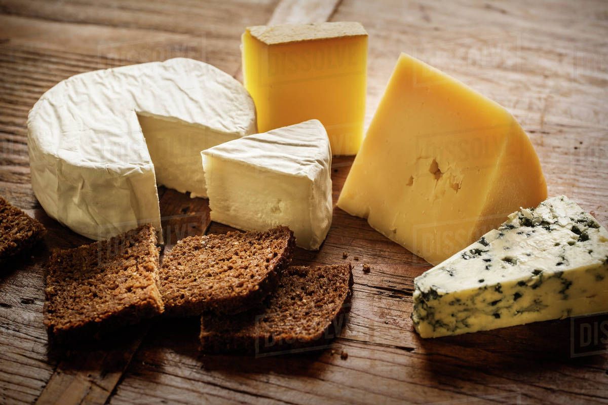 Assorted cheeses and bread slices Stock Photo Dissolve