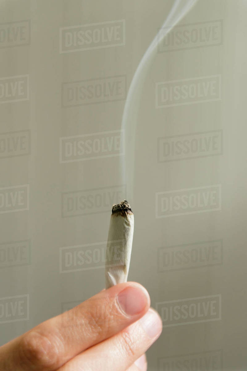 Hand of woman holding marijuana joint Stock Photo Dissolve