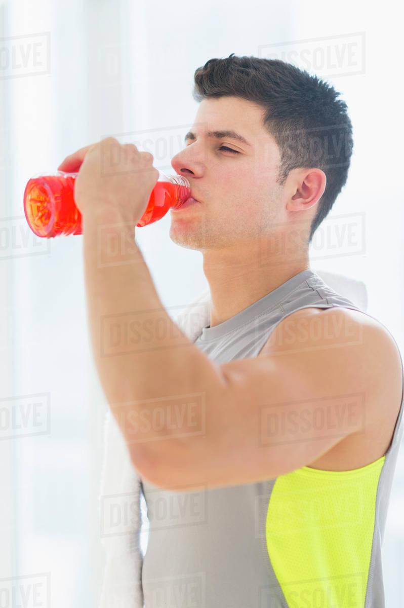 Young man drinking sports drink Stock Photo Dissolve