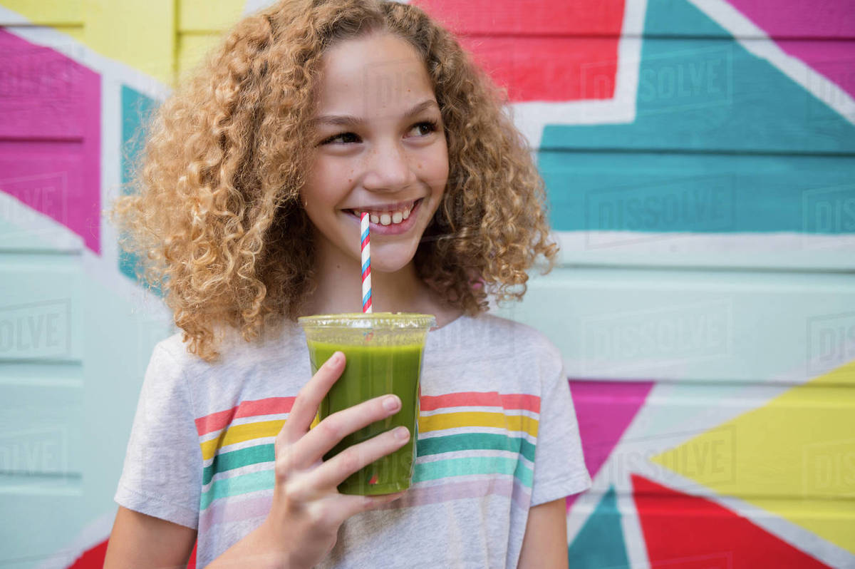 Girl drinking green juice Stock Photo Dissolve
