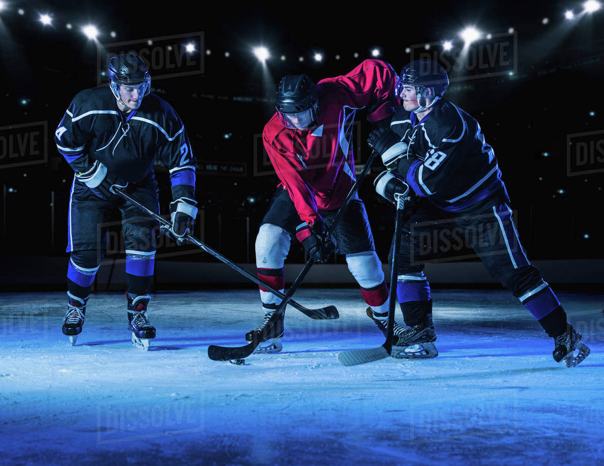 Hockey players fighting for puck Stock Photo Dissolve