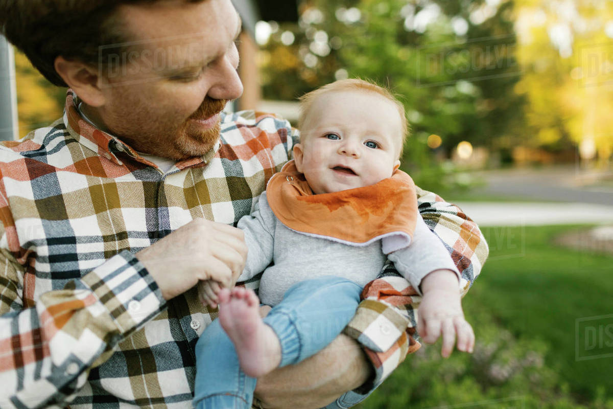 Father carrying baby boy outdoors Stock Photo Dissolve