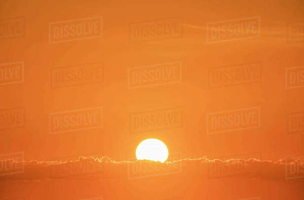 Sun rising in orange sky - Royalty-free Stock Photo | Dissolve