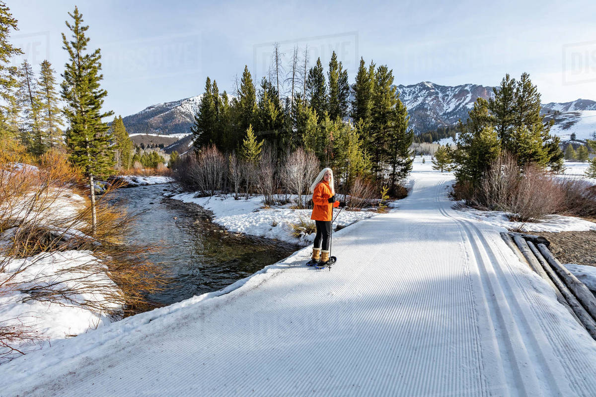 USA, Idaho, Ketchum, Senior blonde woman snowshoeing in snow covered