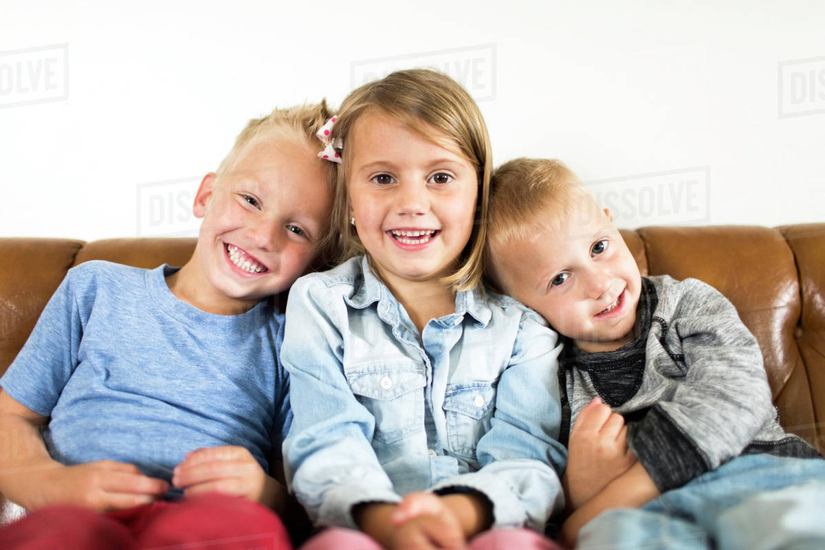 Smiling Children 2 3 4 5 Sitting On Sofa Stock Photo Dissolve