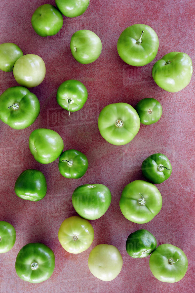 Green tomatillos on red background Stock Photo Dissolve