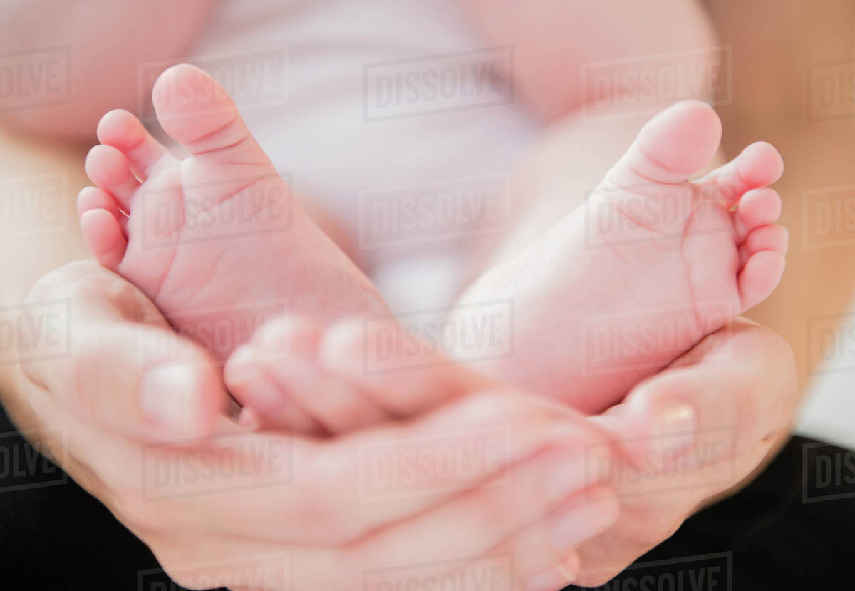 mother holding feet of baby boy 2 5 months stock photo dissolve