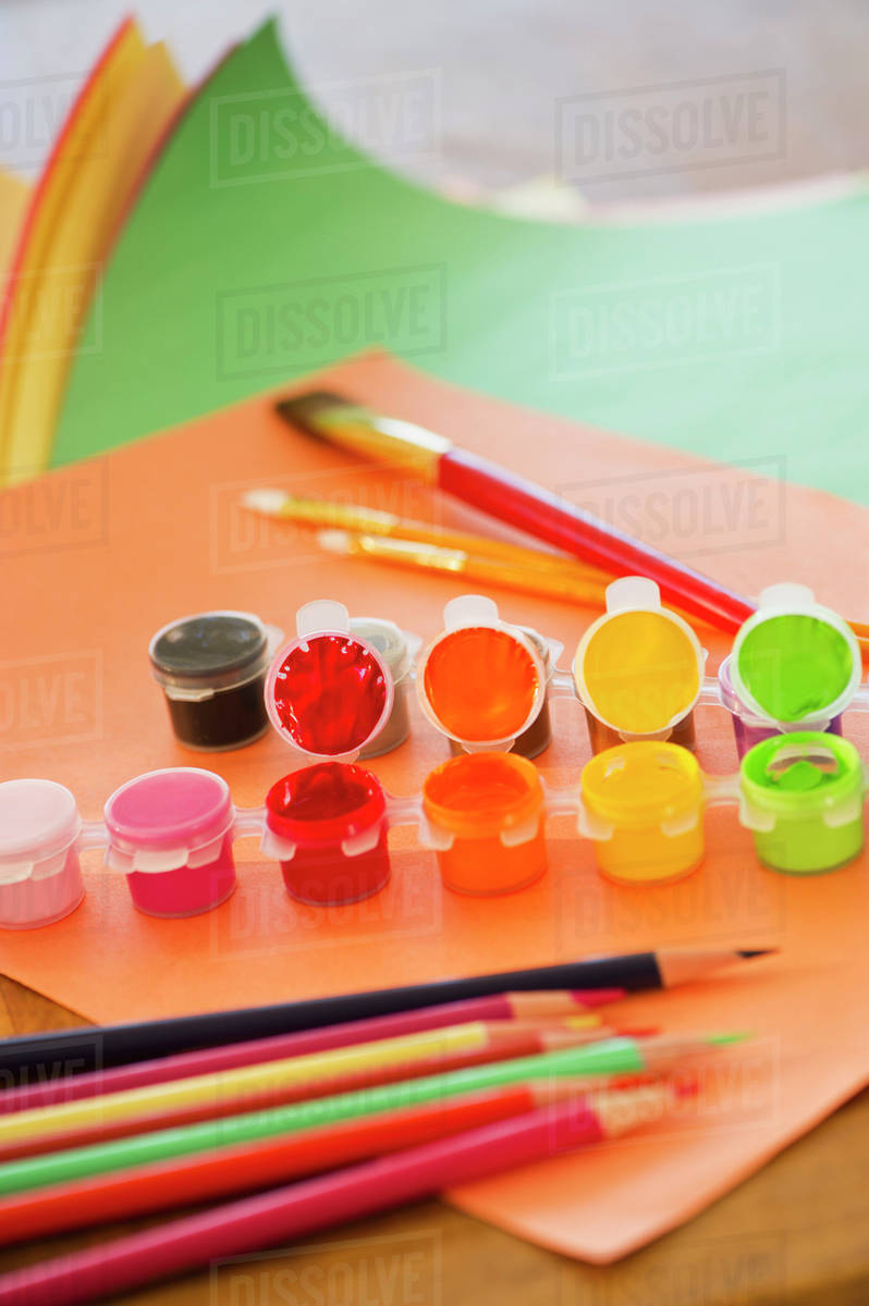Close up of watercolor paints, crayons and paintbrushes, studio shot Stock Photo Dissolve