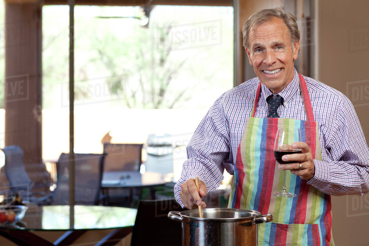 Portrait of man cooking and drinking wine Stock Photo Dissolve