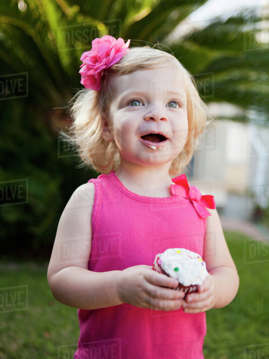 Girl holding cupcake Stock Photo Dissolve