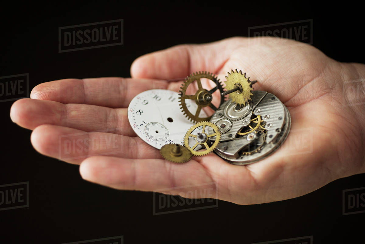 Close up of hand holding clock parts - Royalty-free Stock Photo | Dissolve