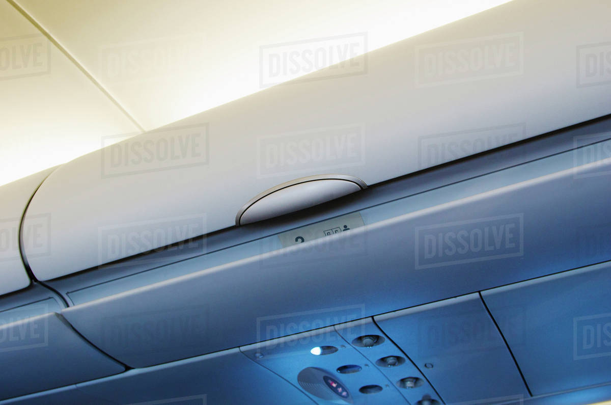 Overhead storage compartment in airplane Stock Photo Dissolve