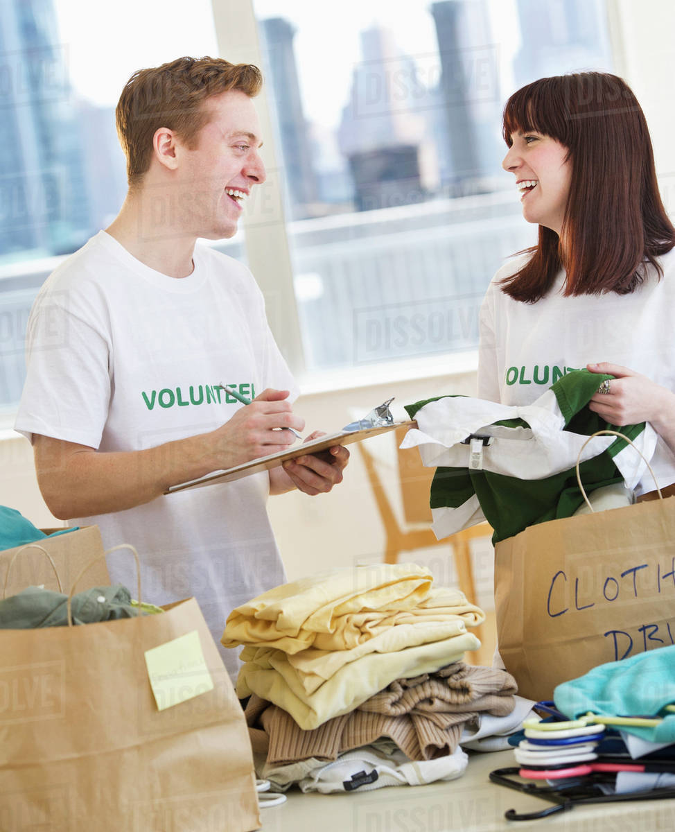 Volunteers organizing clothing drive Stock Photo Dissolve