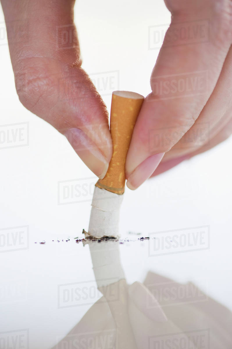 Hand putting out cigarette Stock Photo Dissolve