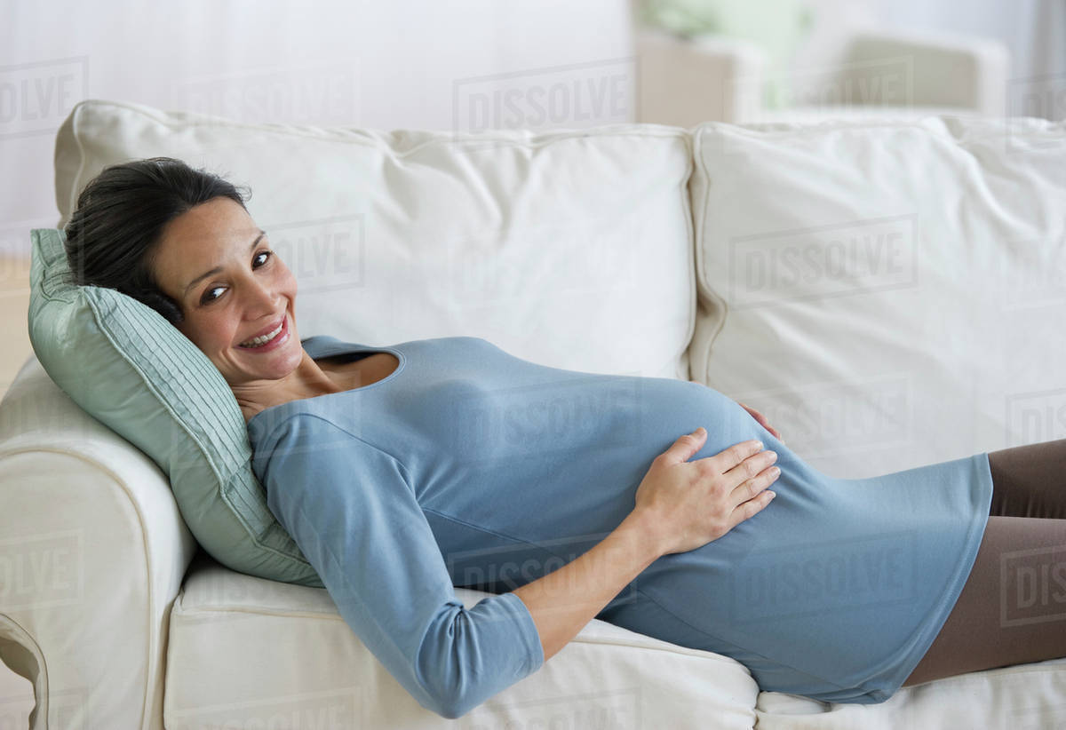 Pregnant woman resting on couch Stock Photo Dissolve