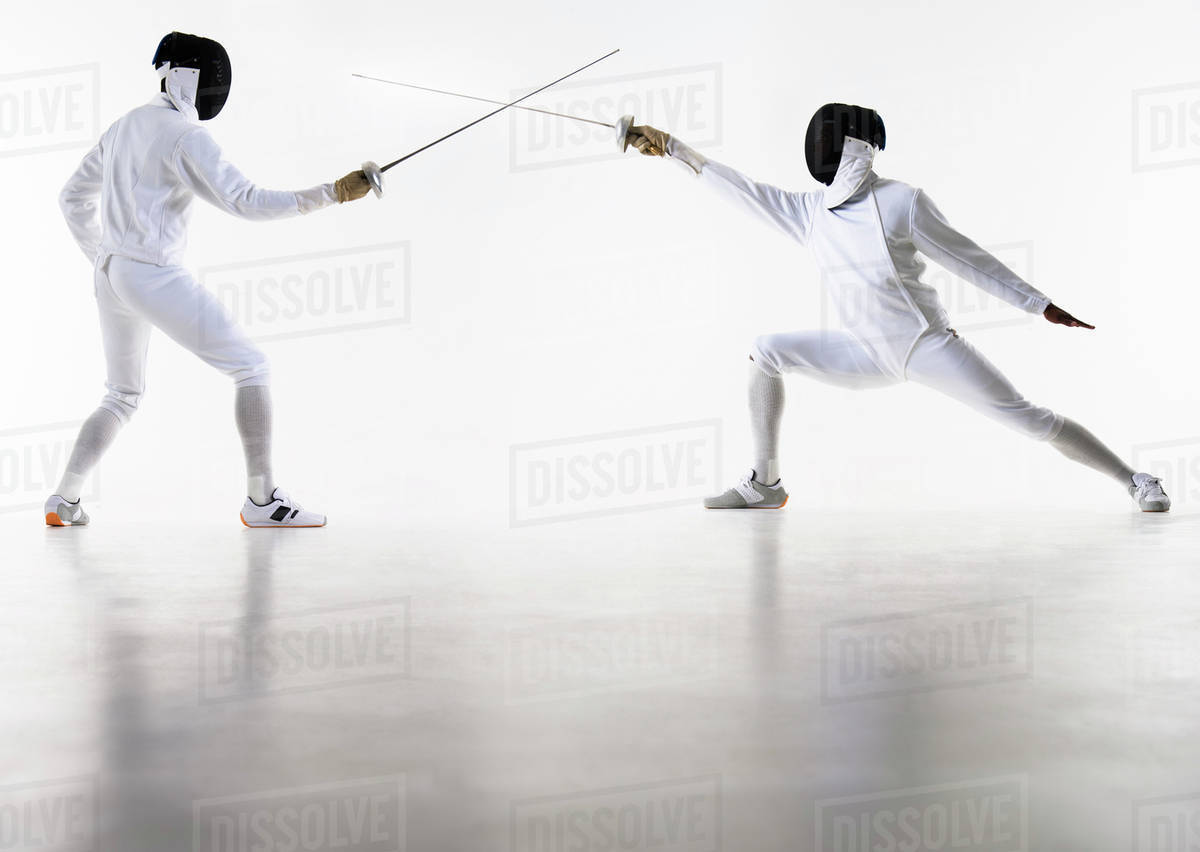 Studio shot of fencers in attacking lunge Stock Photo Dissolve