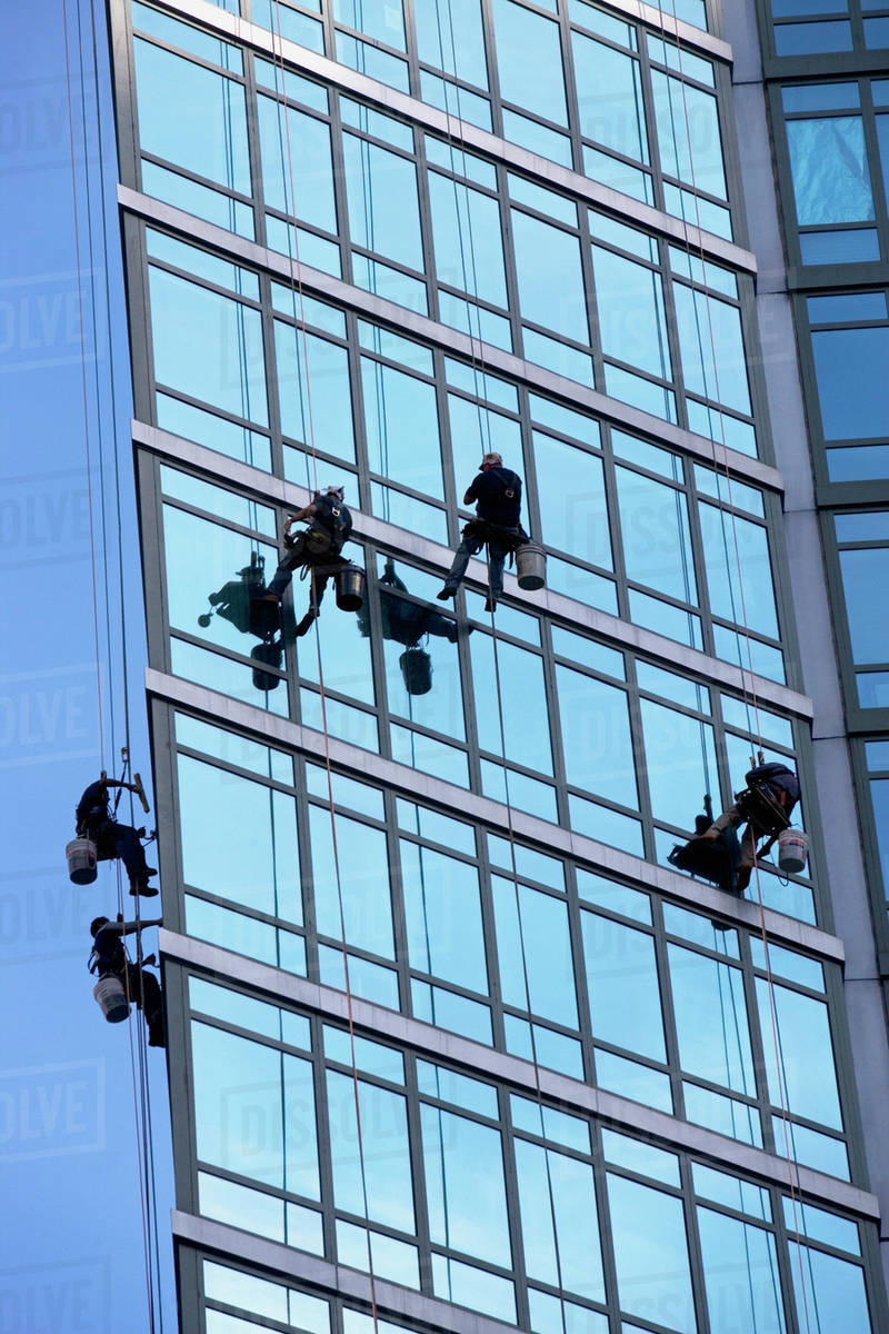 Window washers cleaning windows on skyscraper Stock Photo Dissolve