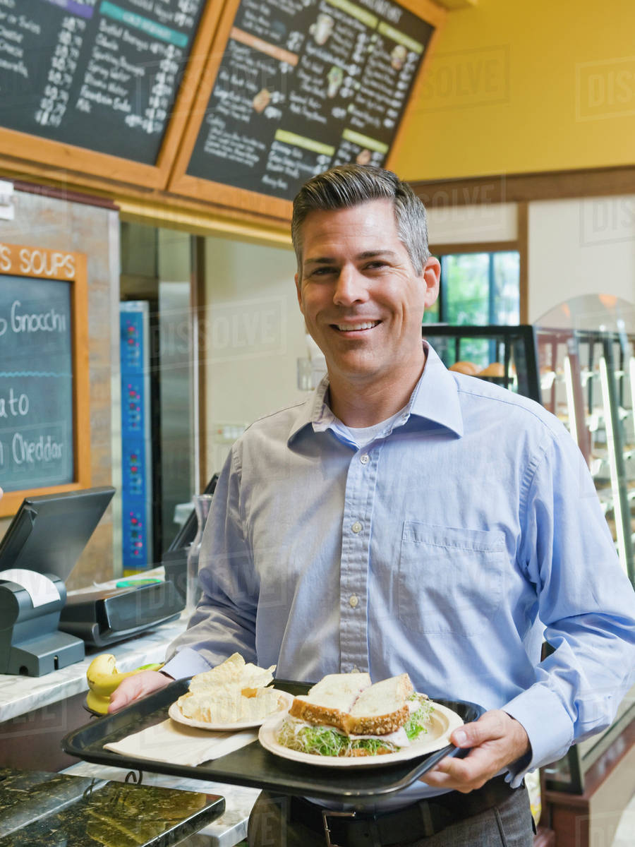Man carrying sandwich on tray Stock Photo Dissolve