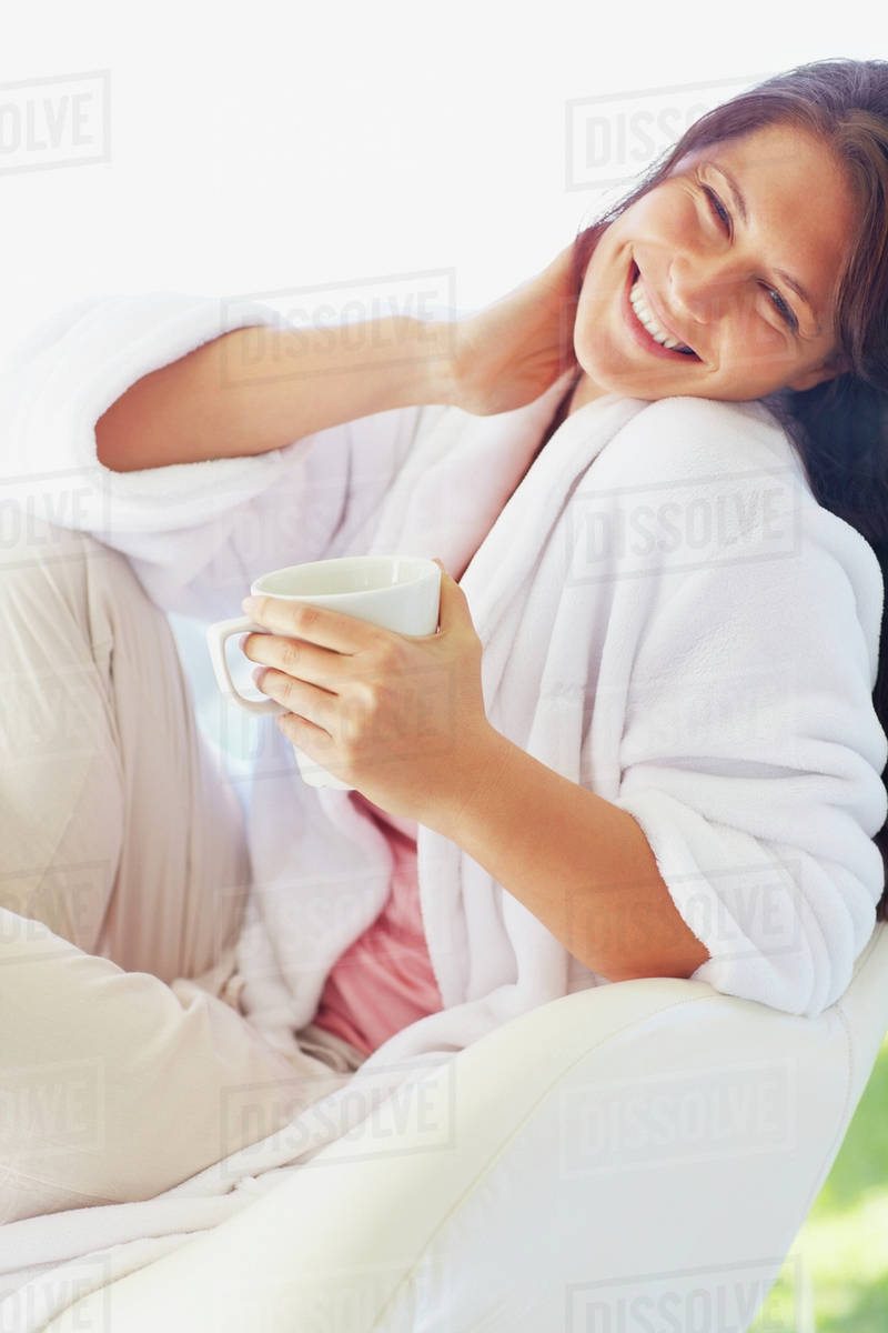 Woman in bathrobe drinking coffee Stock Photo Dissolve