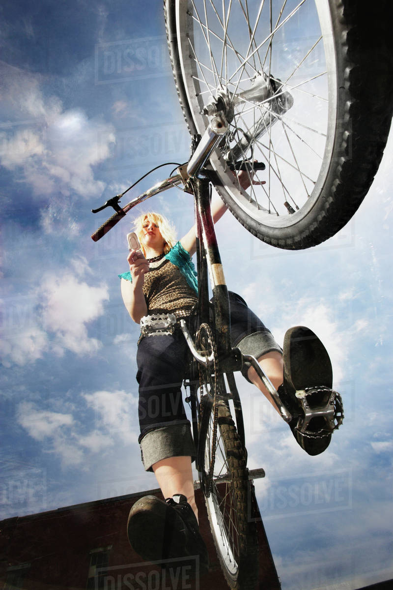 Teenage girl doing a bike trick Stock Photo Dissolve