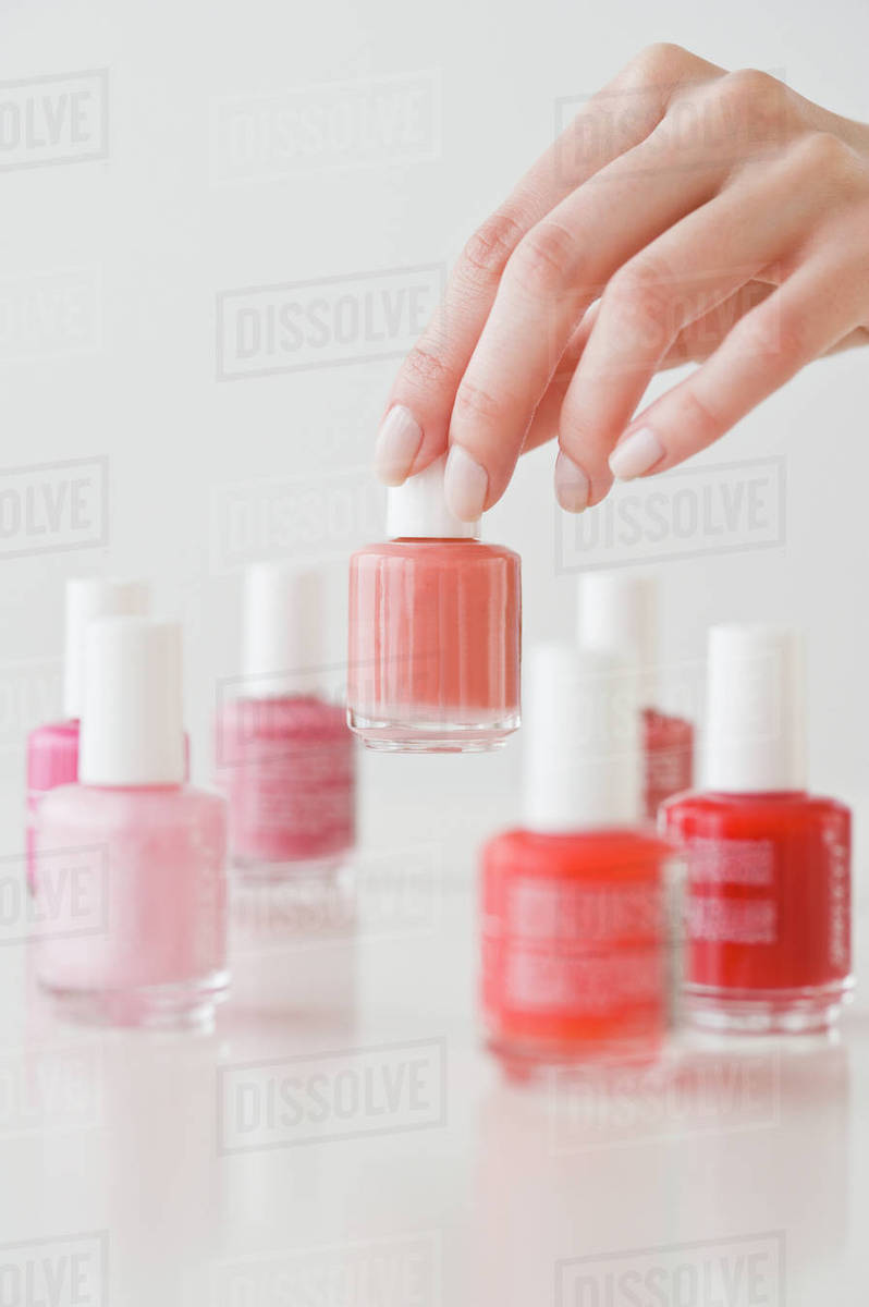 Woman choosing nail polish Stock Photo Dissolve