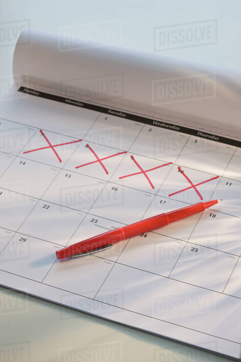 Close up calendar with days marked off Stock Photo Dissolve