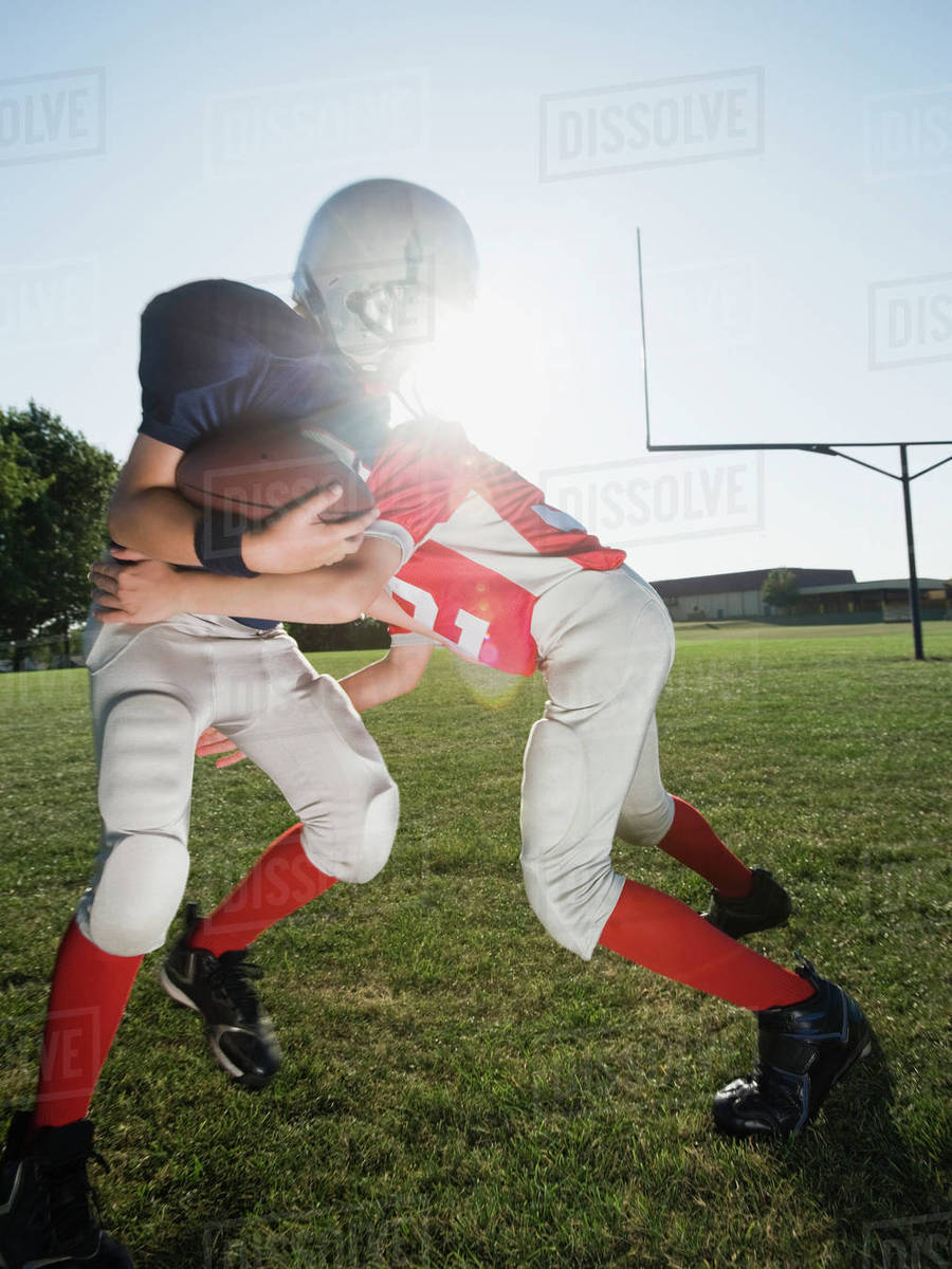 Football player tackling opponent Stock Photo Dissolve
