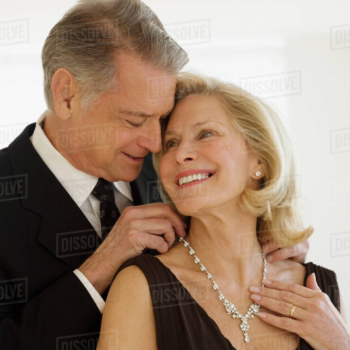 Senior man giving diamond necklace to wife Stock Photo Dissolve
