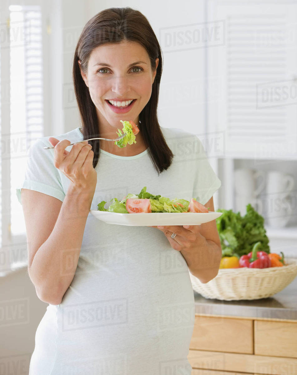 Pregnant woman eating salad Stock Photo Dissolve