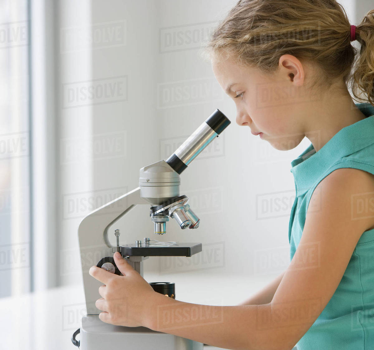 Girl looking into microscope Stock Photo Dissolve