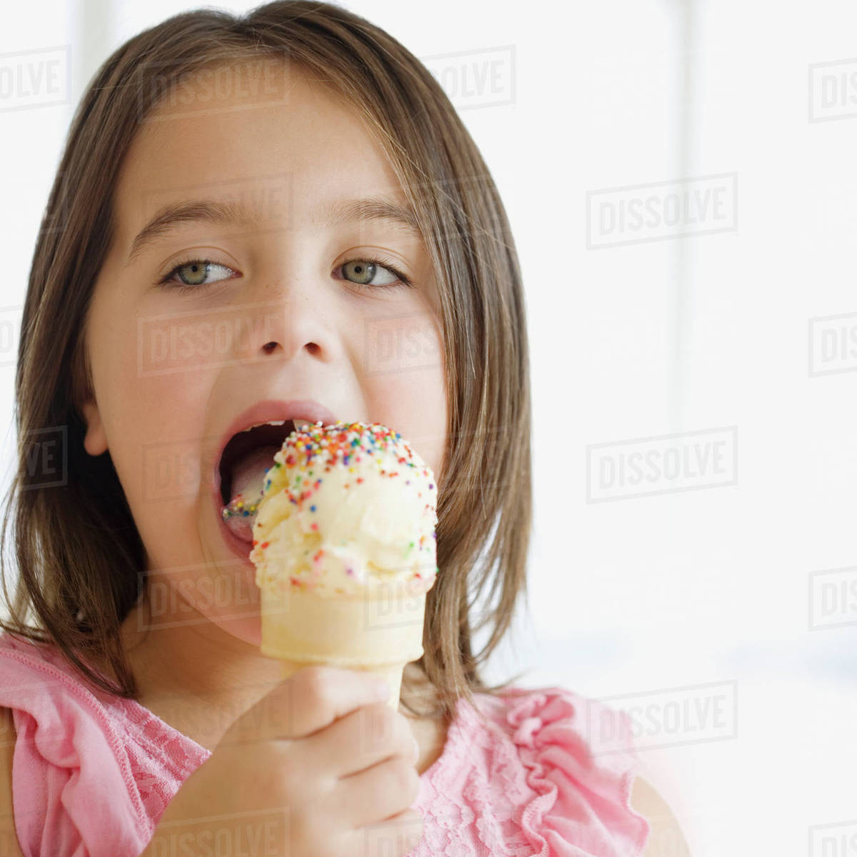 Close up of girl eating ice cream cone Stock Photo Dissolve