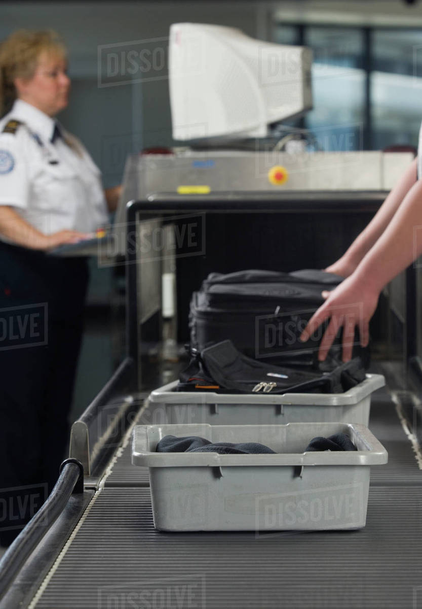 Airport security worker checking baggage Stock Photo Dissolve