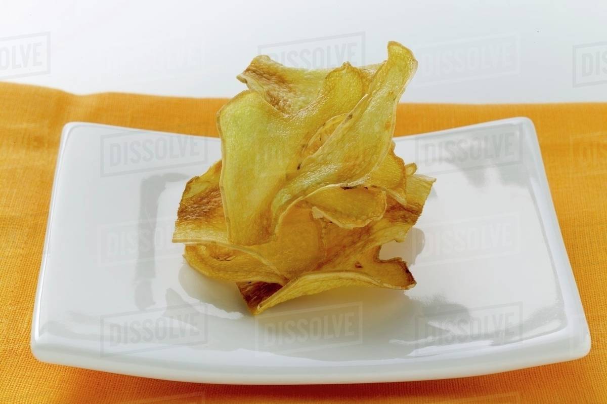 Deepfried ginger slices on plate Stock Photo Dissolve