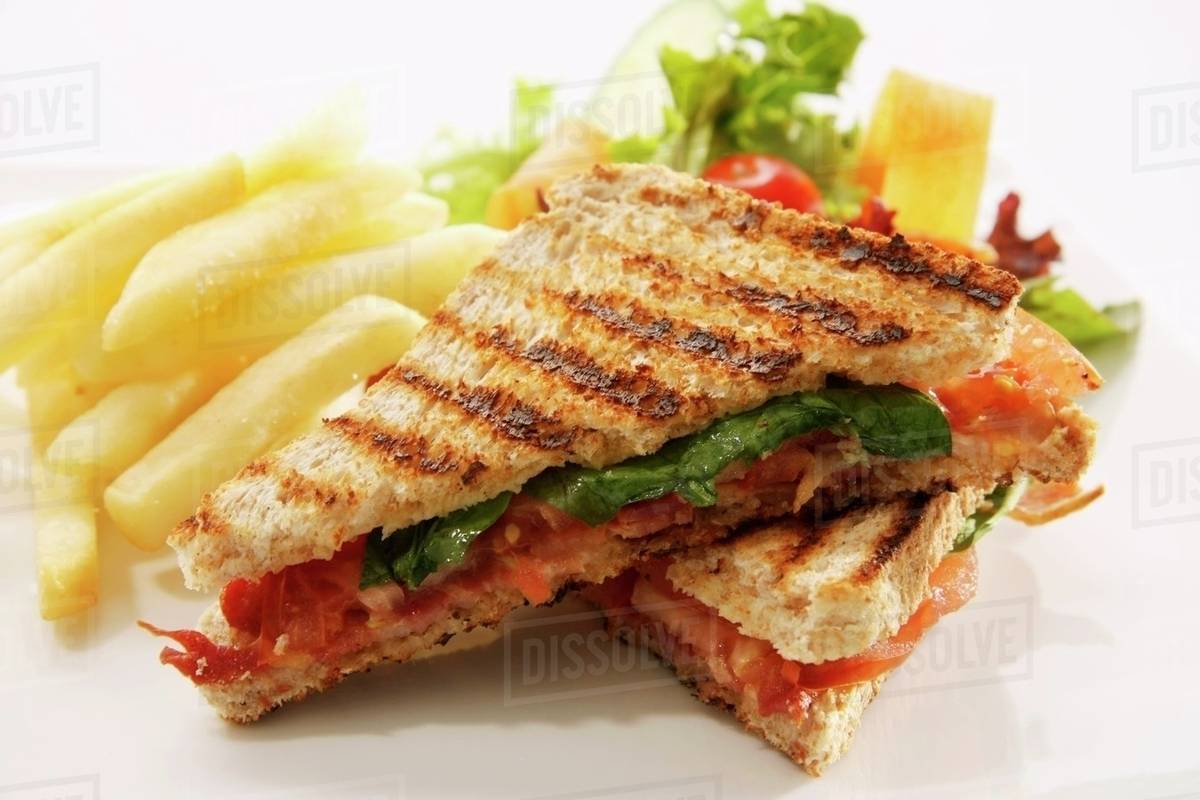 Toasted cheese and tomato sandwich with chips and a salad Stock Photo