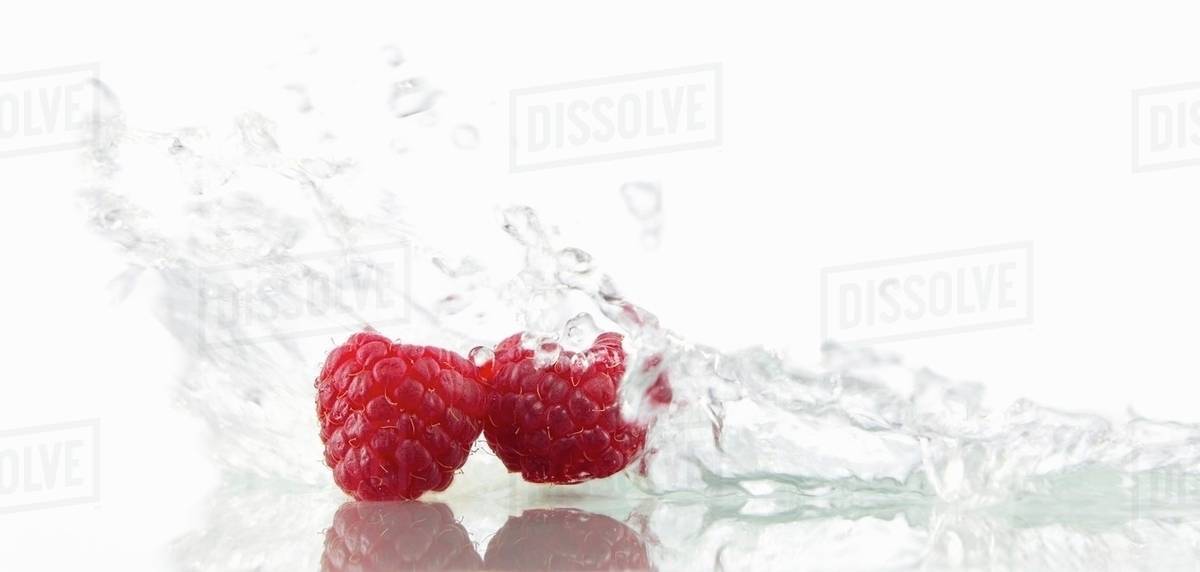Raspberries with splashing water Stock Photo Dissolve
