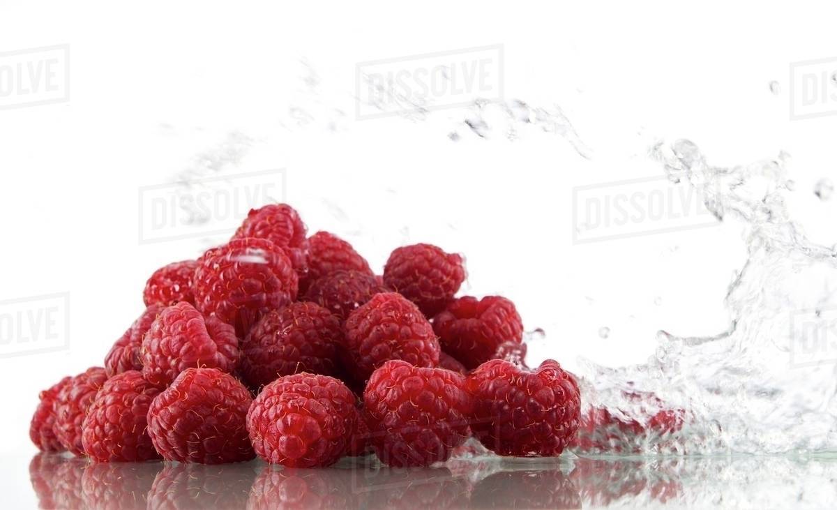 Raspberries with splashing water Stock Photo Dissolve