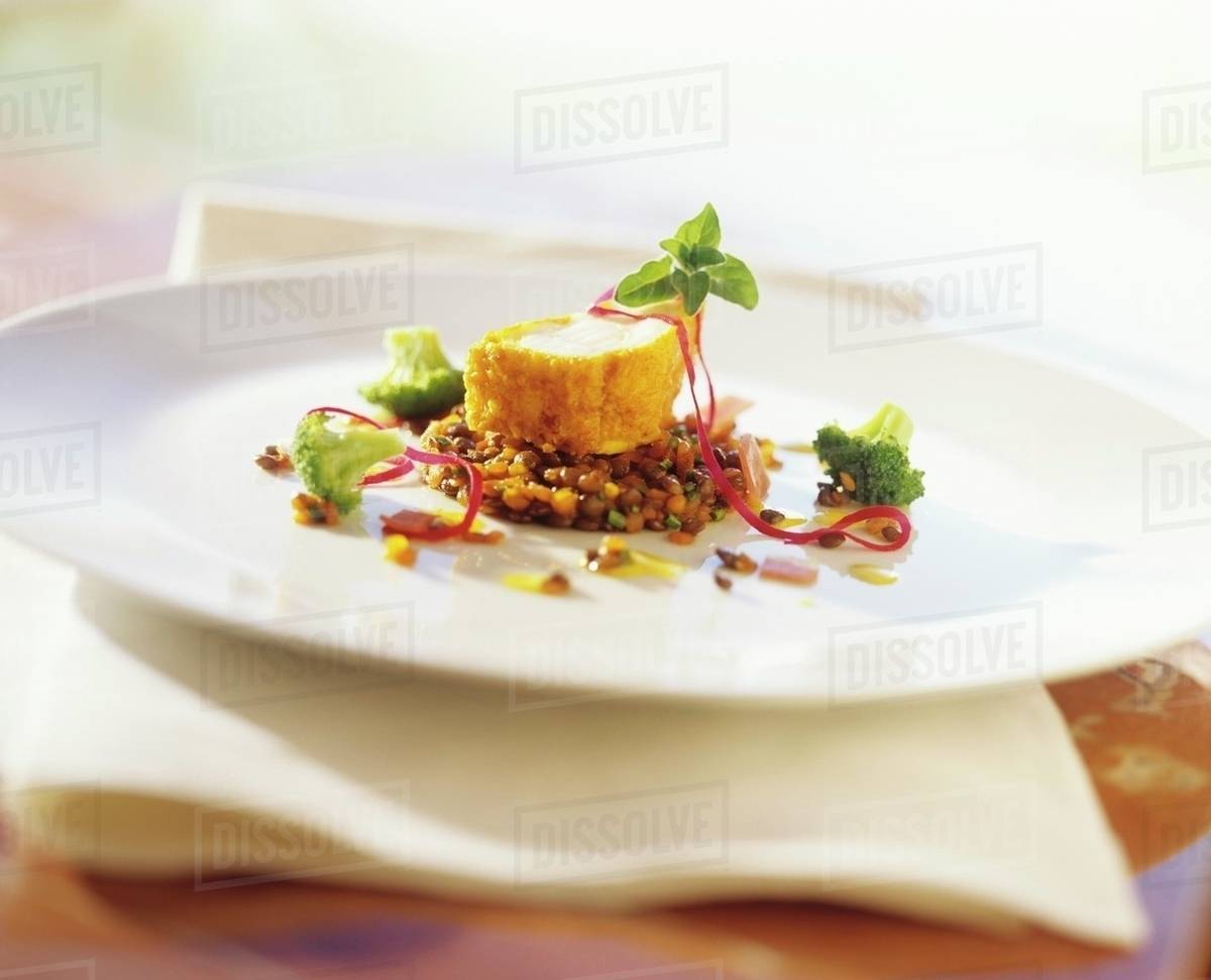 Deepfried monkfish on lentils with broccoli Stock Photo Dissolve