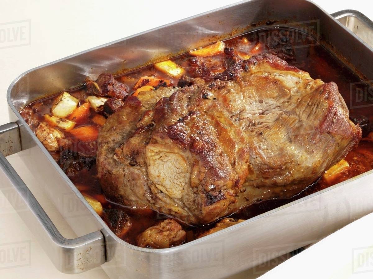 Roast pork (neck) in roasting tin Stock Photo Dissolve