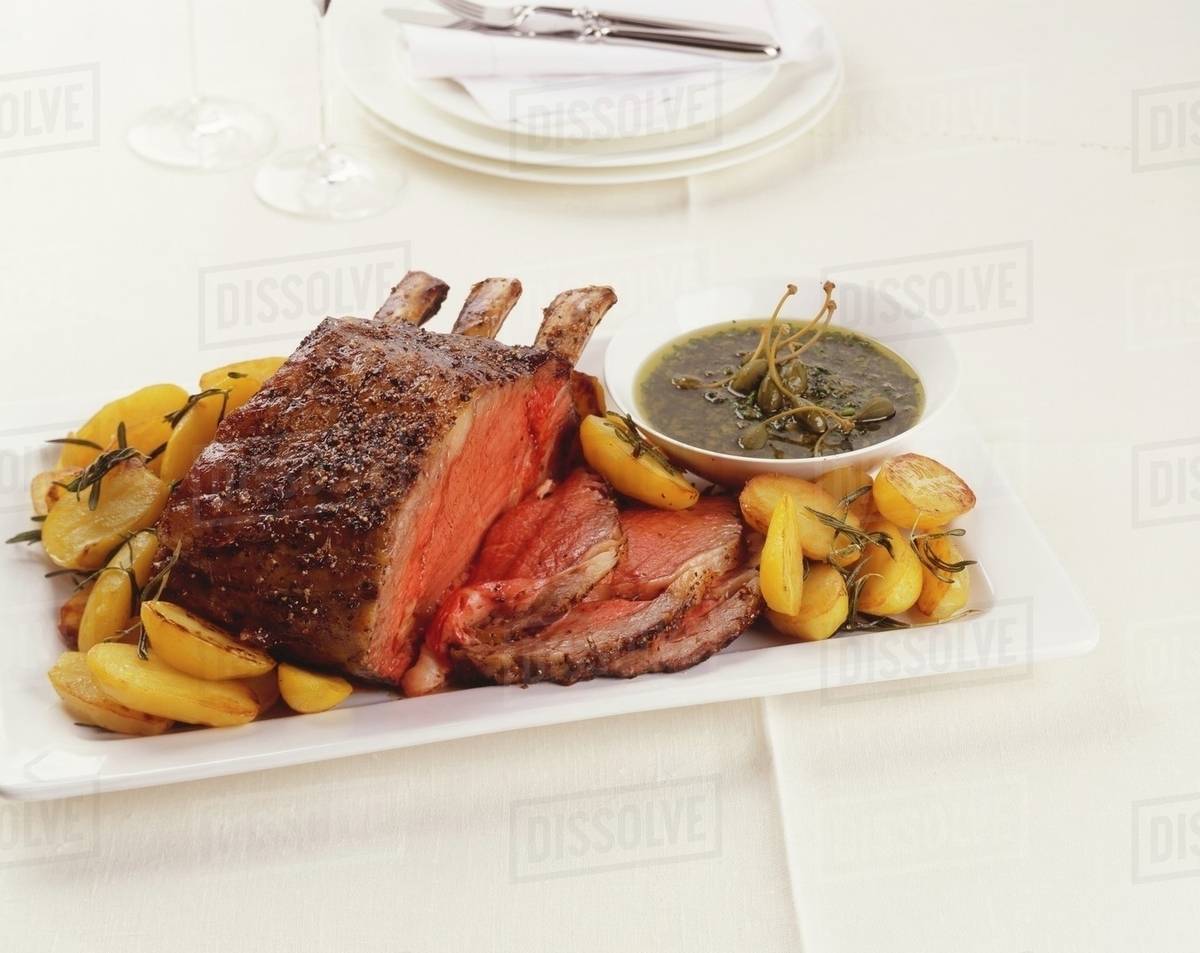 Fore rib of beef with roast potatoes and caper sauce Stock Photo