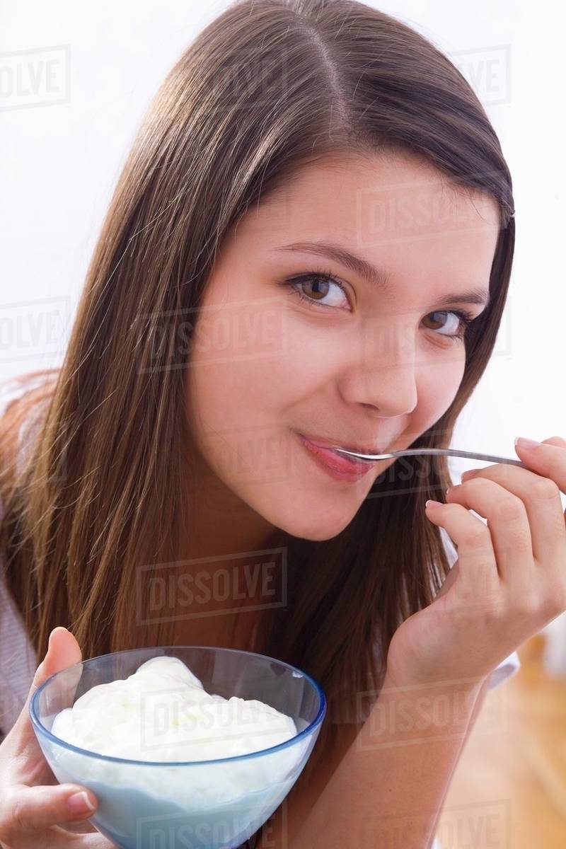 Girl eating yoghurt Stock Photo Dissolve