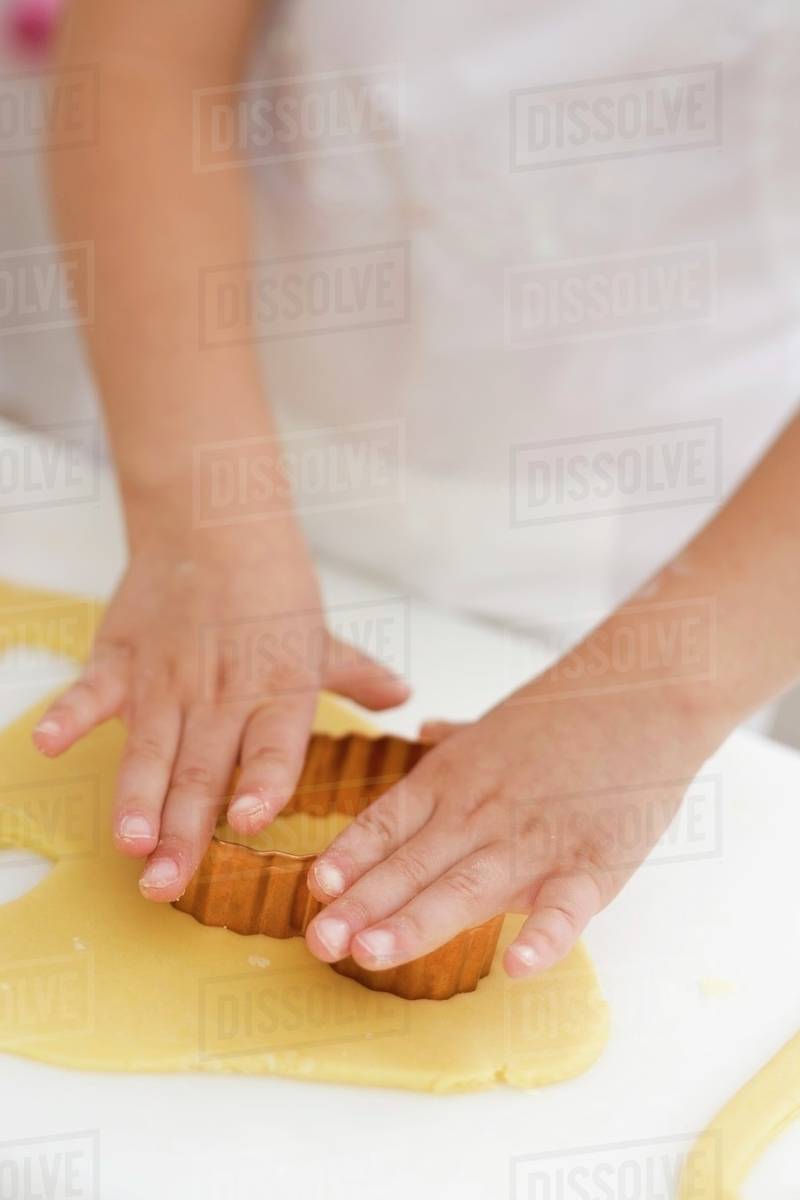 Child cutting out a biscuit Stock Photo Dissolve